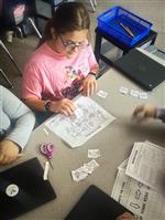 A female student sits at a table, working on a coding project as part of a Black History Month assignment.